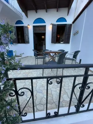 a balcony with chairs and a table in a house at Casa Nikolou Halki in Halki