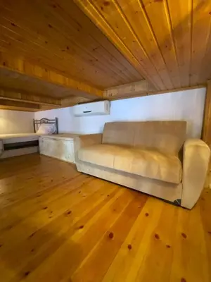 a couch sitting in a room with a wooden floor at Casa Nikolou Halki in Halki