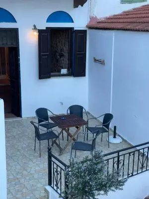 a patio with a table and chairs in front of a building at Casa Nikolou Halki in Halki