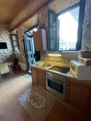 a kitchen with a stove and a sink and a microwave at Casa Nikolou Halki in Halki