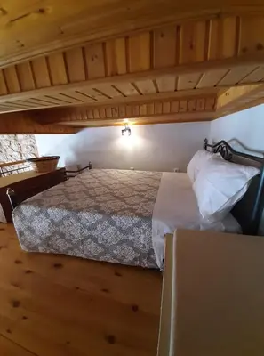 a bedroom with a bed in a room with wooden floors at Casa Nikolou Halki in Halki