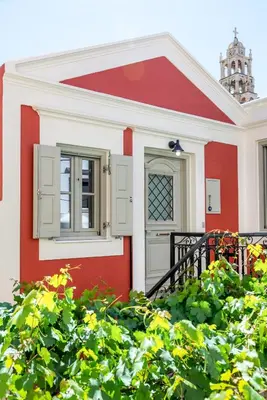a red and white house with a window at Suite Christina in Symi