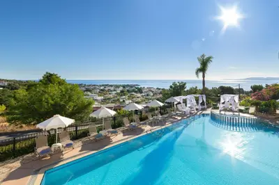 a large swimming pool with chairs and umbrellas at Pefkos View Apartments in Pefki Rhodes