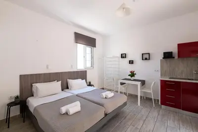 a bedroom with a bed and a desk and a kitchen at Pefkos View Apartments in Pefki Rhodes