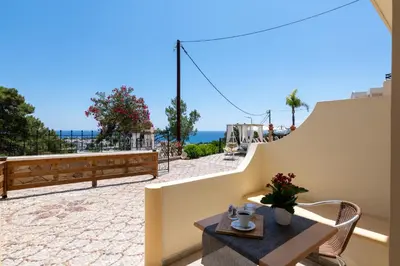 a balcony with a table and a view of the ocean at Pefkos View Apartments in Pefki Rhodes