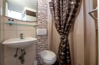a small bathroom with a toilet and a sink at Pefkos View Apartments in Pefki Rhodes