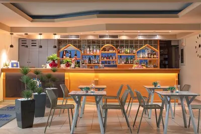 a restaurant with tables and chairs in front of a bar at Pefkos View Apartments in Pefki Rhodes