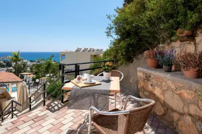 a patio with a table and chairs on a balcony at Pefkos View Apartments in Pefki Rhodes
