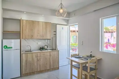 a kitchen with wooden cabinets and a white refrigerator at Joanna Apartments in Haraki
