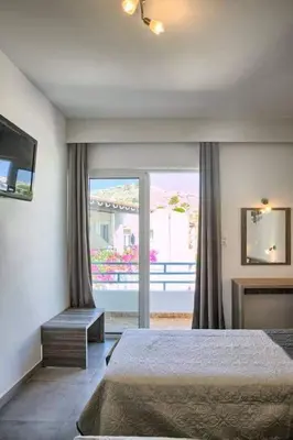 a bedroom with a bed and a large window at Joanna Apartments in Haraki