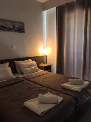 two beds in a hotel room with towels on them at Joanna Apartments in Haraki