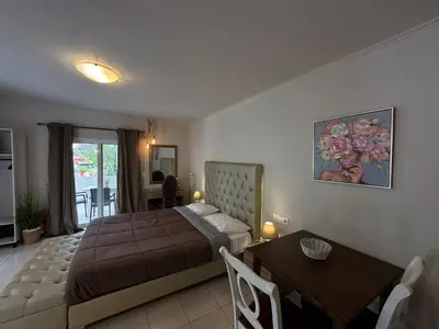 a bedroom with a bed and a table and a dining room at Bay View in Faliraki