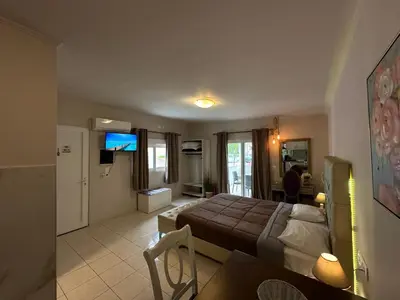 a bedroom with a bed and a living room at Bay View in Faliraki