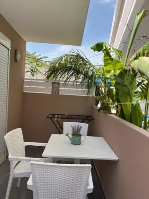 a white table and chairs on a balcony with plants at Bay View in Faliraki