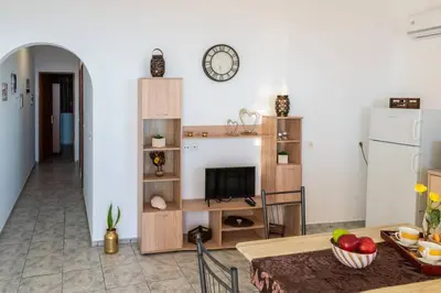a living room with a table and a kitchen at Tsampika's Beachfront House in Stegna in Archangelos