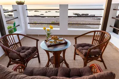 a living room with a table and chairs and a couch at Tsampika's Beachfront House in Stegna in Archangelos