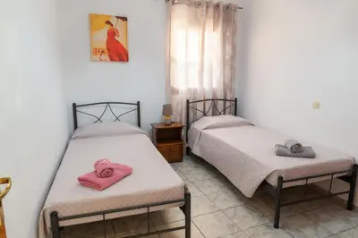 two beds with pink towels on them in a room at Tsampika's Beachfront House in Stegna in Archangelos
