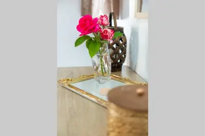 a vase with red flowers sitting on a glass table at Tsampika's Beachfront House in Stegna in Archangelos
