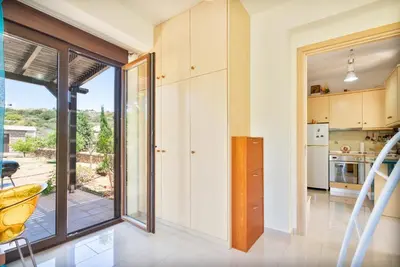 a kitchen with a sliding glass door leading to a patio at Smaragdi Beachfront Villa in Asklipiḯon