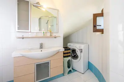 a bathroom with a sink and a washing machine at Smaragdi Beachfront Villa in Asklipiḯon