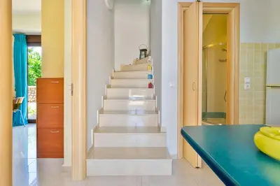 a staircase in a kitchen with a blue counter at Smaragdi Beachfront Villa in Asklipiḯon