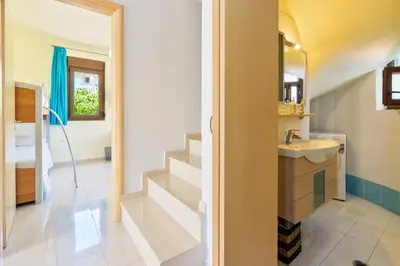 a bathroom with a sink and a staircase at Smaragdi Beachfront Villa in Asklipiḯon