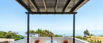 a view of the ocean from the balcony of a house at Smaragdi Beachfront Villa in Asklipiḯon