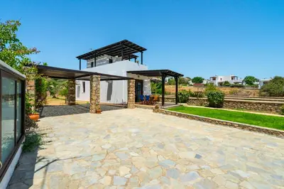 a stone patio in front of a house at Smaragdi Beachfront Villa in Asklipiḯon