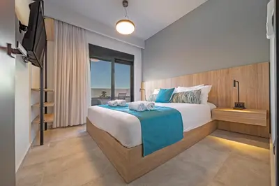 a bedroom with a large bed and a television at Amarada Marina Suites in Rhodes Town