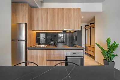 a kitchen with wooden cabinets and a black counter top at Amarada Marina Suites in Rhodes Town