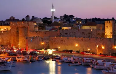 a group of boats in a harbor next to a castle at Naria Medieval House in Rhodes Town