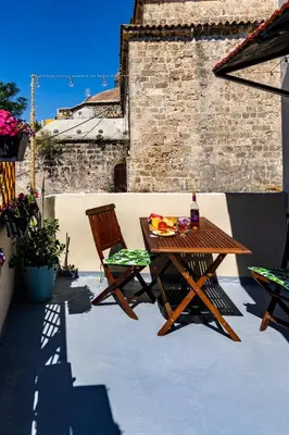 a wooden table and chairs on a patio at Naria Medieval House in Rhodes Town