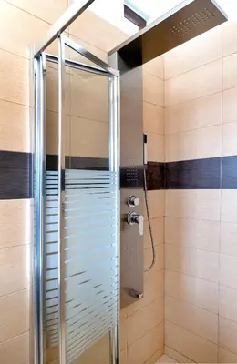 a shower with a glass door in a bathroom at Memi Beach front Villa in Kiotari
