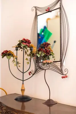 a vase with flowers in front of a mirror at Conchiglia Village House in Kiotari