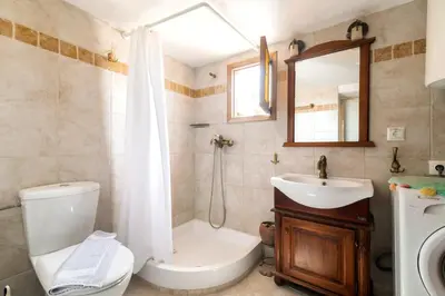 a bathroom with a toilet and a sink and a mirror at Conchiglia Village House in Kiotari