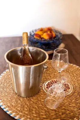 a bottle of wine in a bucket on a table with glasses at Conchiglia Village House in Kiotari