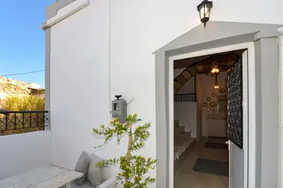 a white house with a door leading to a balcony at Rhodes Archangelos Traditional village house in with private yard in Archangelos