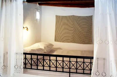 a bedroom with a bed and a window with curtains at Rhodes Archangelos Traditional village house in with private yard in Archangelos