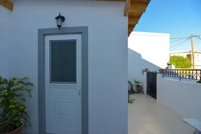 a white door on the side of a white house at Rhodes Archangelos Traditional village house in with private yard in Archangelos