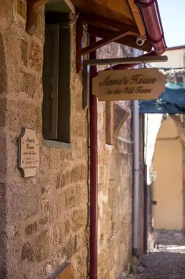 a sign on the side of a brick building at Anna's house in the Old Town in Rhodes Town