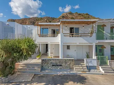 a white house with a mountain in the background at Ammos stegna in Archangelos