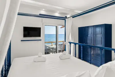 a bedroom with a bed and a view of the ocean at Ammos stegna in Archangelos