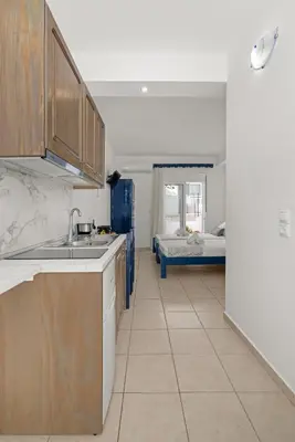a kitchen with a sink and a room with a bed at Ammos stegna in Archangelos