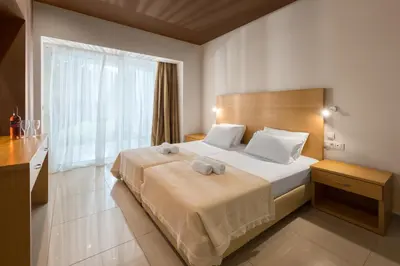 a bedroom with a bed and a large window at Anavadia Hotel-All Inclusive in Kolimbia