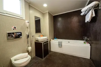 a bathroom with a toilet and a tub and a sink at Anavadia Hotel-All Inclusive in Kolimbia