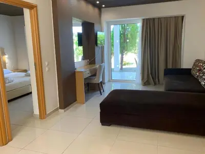 a living room with a couch and a piano at Anavadia Hotel-All Inclusive in Kolimbia