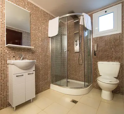 a bathroom with a shower and a toilet and a sink at Anavadia Hotel-All Inclusive in Kolimbia
