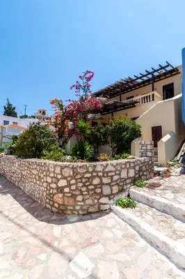 a stone retaining wall next to a house at Kiki&Nina in Halki