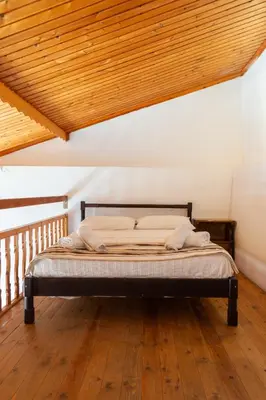 a bed in a room with a wooden ceiling at Kiki&Nina in Halki