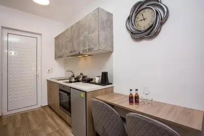 a kitchen with a counter and a clock on the wall at Dimitra Faliraki Center Apartments in Faliraki